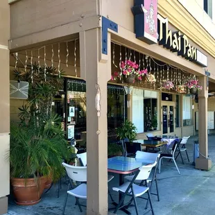 outside of a restaurant with tables and chairs