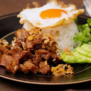 a plate of food with rice, meat, and an egg