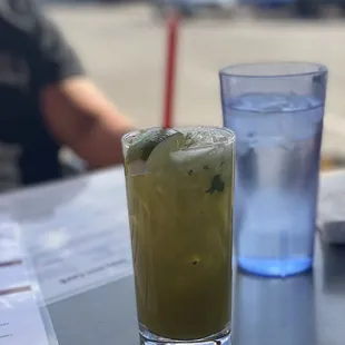 a glass of water and a drink on a table