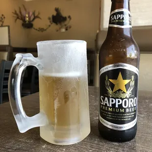 a glass of beer and a bottle of sapporo