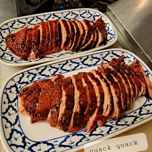 sliced pork on a blue and white plate
