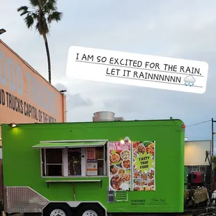 a green food truck parked in a parking lot