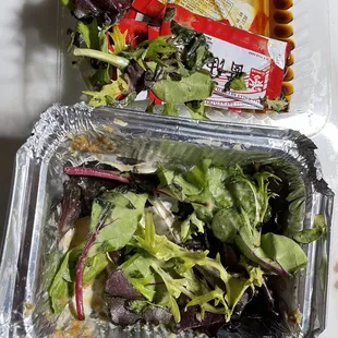 two containers of salad and a packet of noodles