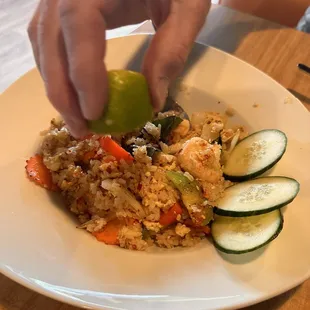 a person putting a lime on a plate of food