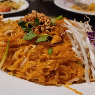 a plate of noodles with meat and vegetables