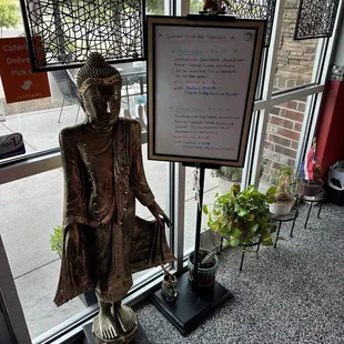 a buddha statue in front of a window
