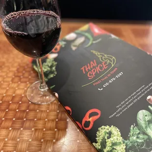 a glass of red wine and a menu