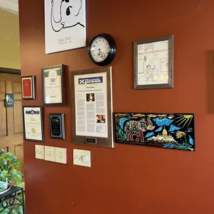 a wall with a clock and posters on it