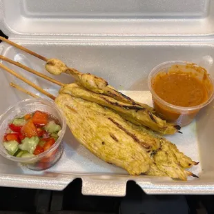 skewered food in a styrofoam container