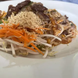 a plate of noodles with meat and vegetables