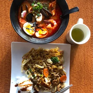 a bowl of noodles and chopsticks on a table