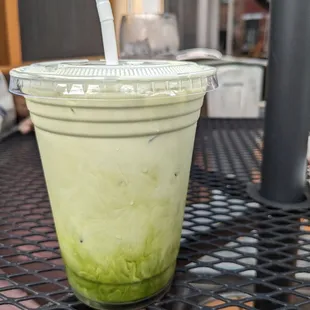 a green smoothie in a plastic cup