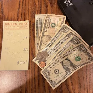 a bunch of money and a note on a table