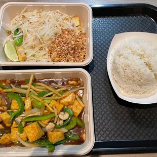 a tray of rice, chicken, and veggies