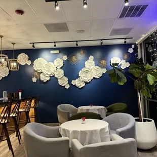 a restaurant with blue walls and white paper flowers on the wall