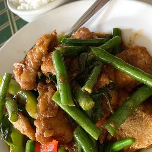 a plate of stir fried green beans and chicken