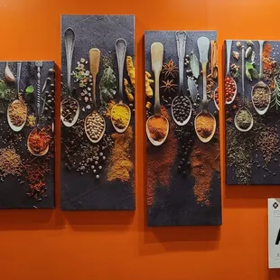spices and spoons on a wall