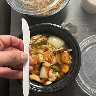 a person holding a spoon over a bowl of food
