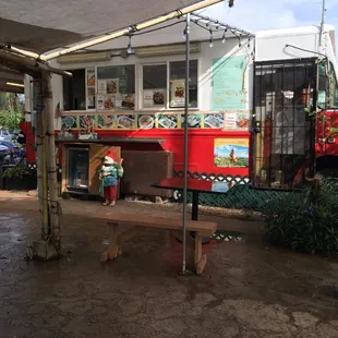 a red food truck parked under a canopy