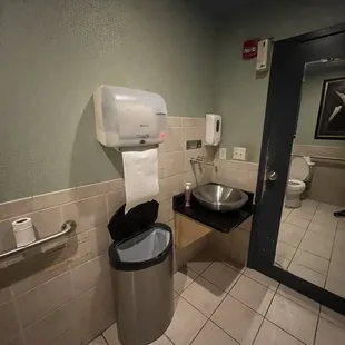 a bathroom with a toilet and a trash can