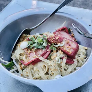 BA ME MOO DANG:BBQ Pork, fresh egg noodles tossed with bean sprouts, yu choy, peanuts , cilantro, scallion, toasted garlic