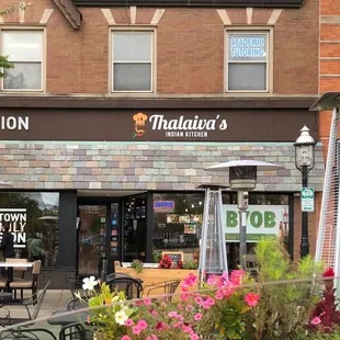 Storefront in summertime, and with curbside dining.