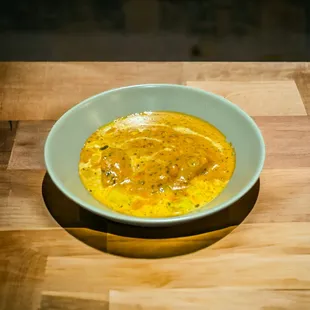 a bowl of soup on a wooden table