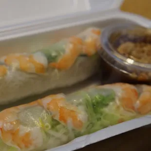 shrimp and lettuce rolls in a styrofoam container
