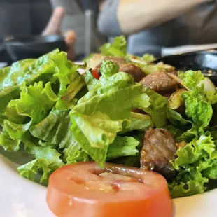 a salad with meat and tomatoes