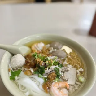 a bowl of soup with noodles and shrimp