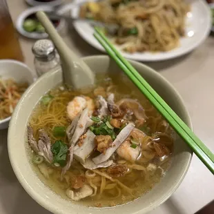 a bowl of soup with chopsticks