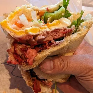 a hand holding a sandwich