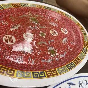 a red plate with chinese writing on it