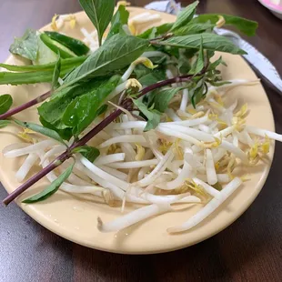 a plate of bean sprouts and greens