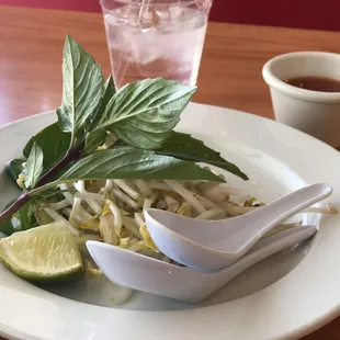 a white plate with a salad and a drink