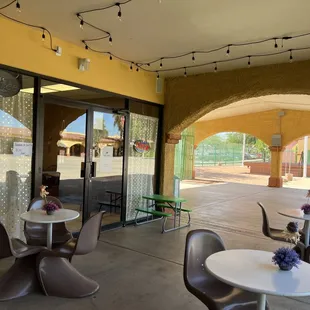 a patio with tables and chairs