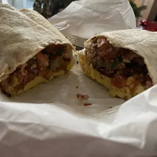 Breakfast Burrito with perfectly cooked eggs, sausage, bacon, tots, cheese, pico de gallo and hot sauce made in house.