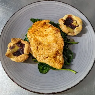 Fancy Chick-
Marinated chicken breast over a bed of collards and spinach, with a pair of brie and cranberry puff pastries