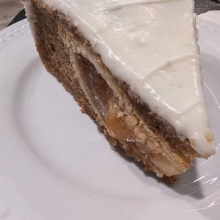 An apple pie is baked into a spice cake with cream cheese frosting.