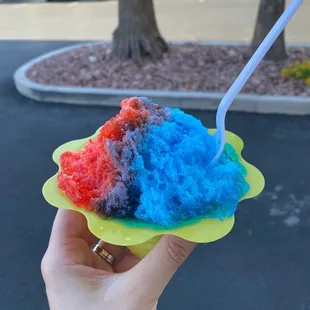 a hand holding a colorful ice cream