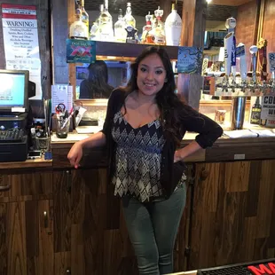 a woman standing in front of a bar