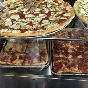 a variety of pizzas on display