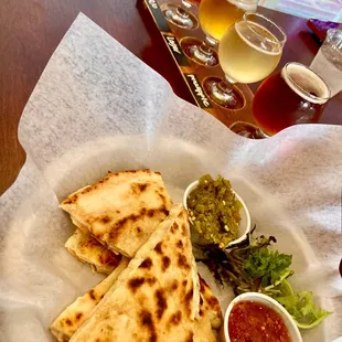 a plate of quesadillas and a glass of beer