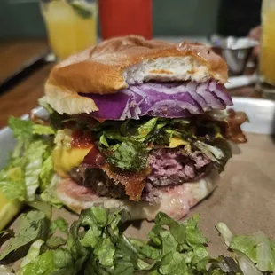 a burger with lettuce, bacon, and cheese