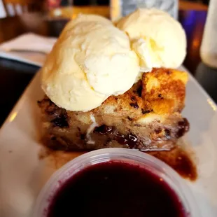 Bacon chocolate chip bread pudding with a side of blueberry sauce.