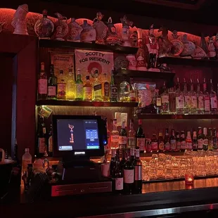 a bar with liquor bottles and a television