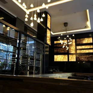 a bar in a restaurant with a large chandelier