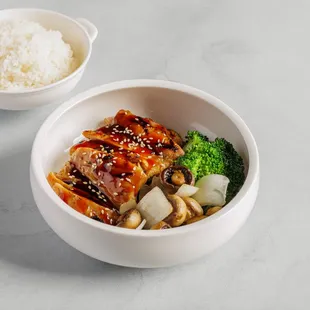 a bowl of food with rice and broccoli