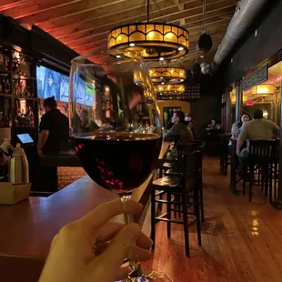 a hand holding a glass of wine