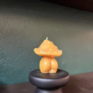 a yellow candle on a black candle holder
